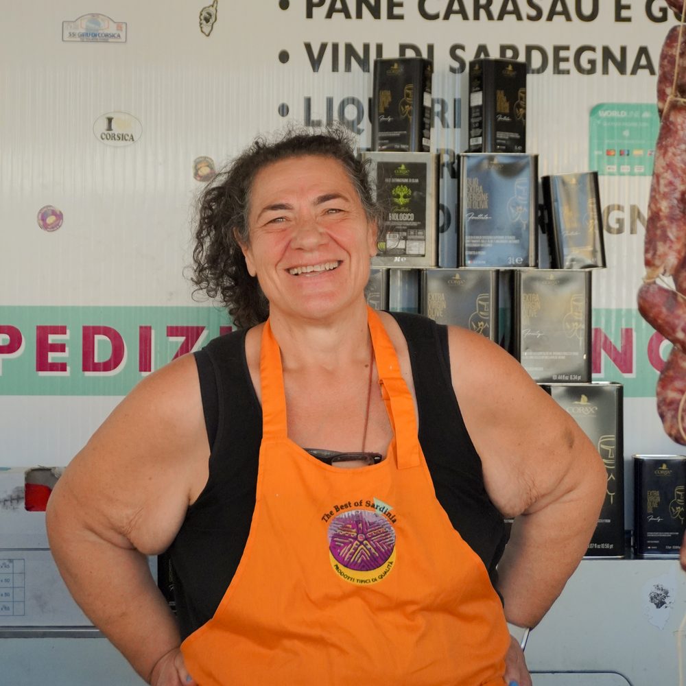 La titolare di The Best of Sardinia sorridente dietro al banco
